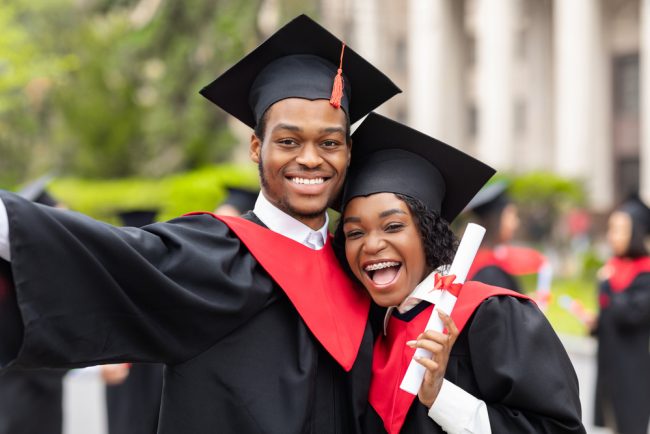 Happy,African,American,Couple,Students,In,Graduation,Dresses,And,Hats